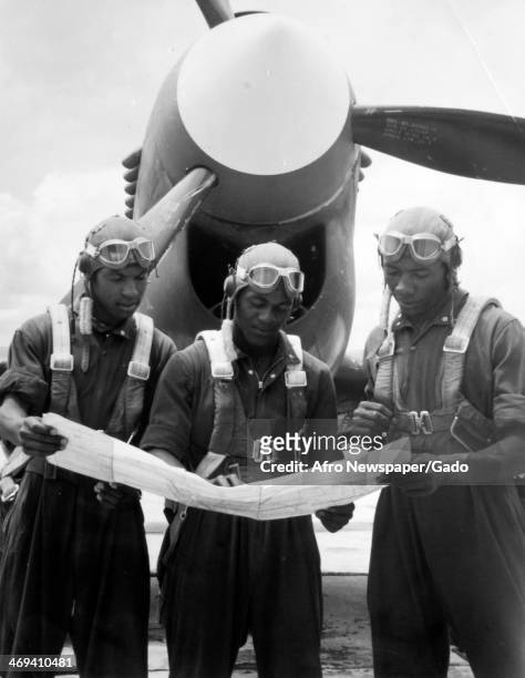 Tuskegee Airmen prepare for a flight from Tuskegee Army Airfield by reading a map, Tuskegee, Alabama, 1943.