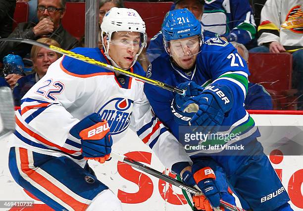Brandon McMillan of the Vancouver Canucks and Keith Aulie of the Edmonton Oilers clash during their NHL game at Rogers Arena April 11, 2015 in...