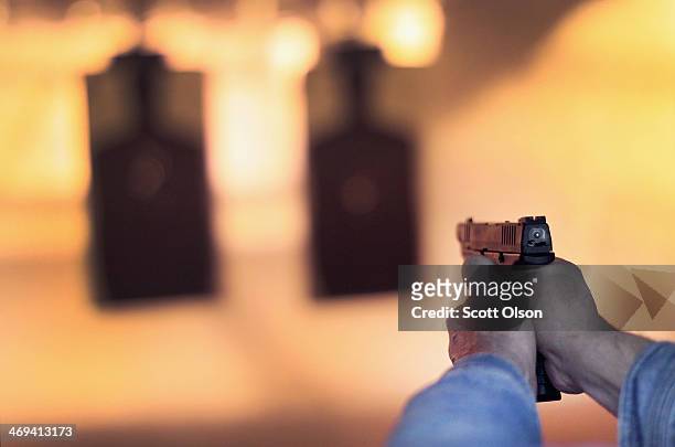 Marksman sights in on a target during a class he was taking to qualify for an Illinois concealed carry permit on February 14, 2014 in Posen,...