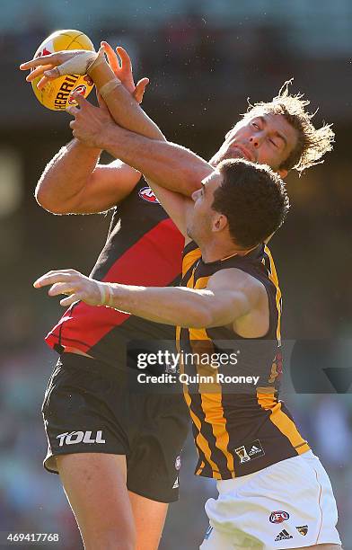 Tom Bellchambers of the Bombers marks over the top of Jonathon Ceglar of the Hawks during the round two AFL match between the Essendon Bombers and...