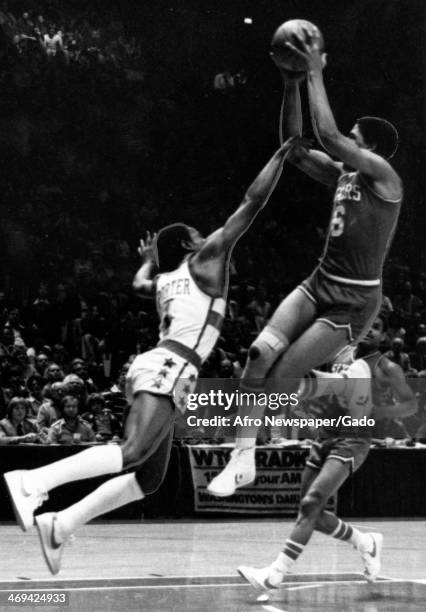 Photograph of Julius Erving, aka Dr J, of the Philadelphia 76ers and Kevin Porter of the Baltimore Bullets during a basketball play off game, April...