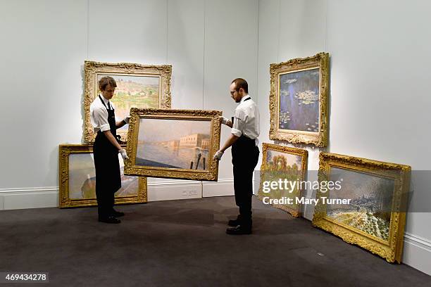 Gallery technicians carry Claude Monet's 'Le Palais Ducal' from a collection of six pieces of the artist's work which are going on show at Sotheby's...