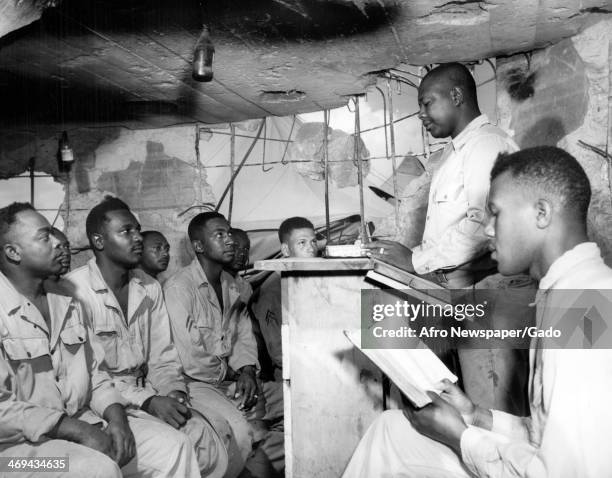 Cpl Willie Benford conducts an informal prayer meeting in ruined Japanese blockhouse at a Marshall Army base, US Army Base, Marshall Islands, 1940.