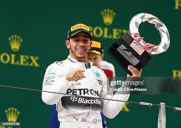 Race Winner Lewis Hamilton of Great Britain and Mercedes GP celebrates with the trophy following the Formula One Grand Prix of China at Shanghai...