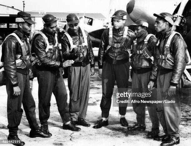 Tuskegee Airmen, African American pilots, talking over Big Ship manoeuvres at Tuskegee Army Air Field, with airplanes in the background, Tuskegee,...