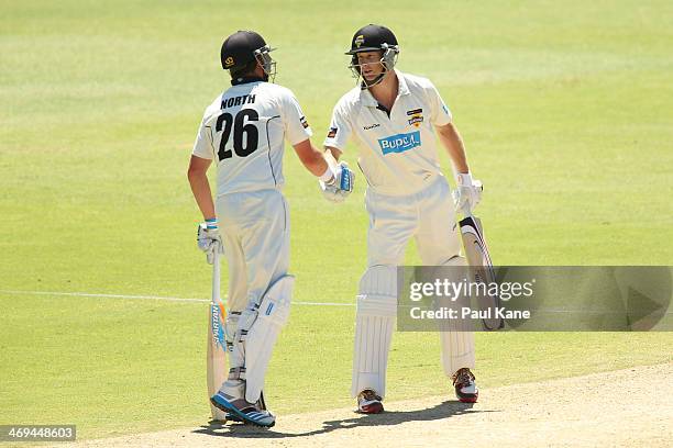 Marcus North of the Warriors congratulates Adam Voges after reaching his half century during day four of the Sheffield Shield match between the...