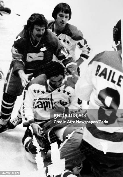 Photograph of an ice hockey game of the Washington Capitals vs Vancouver Canucks, with Capital's Bill Riley battling Vancouver's Mike Walton, 1977.