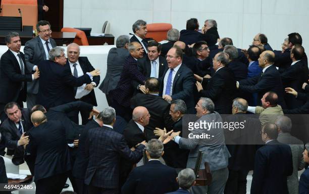 Members of parliament from the ruling AK Party and the main opposition Republican People's Party scuffle during a debate on a draft law which will...