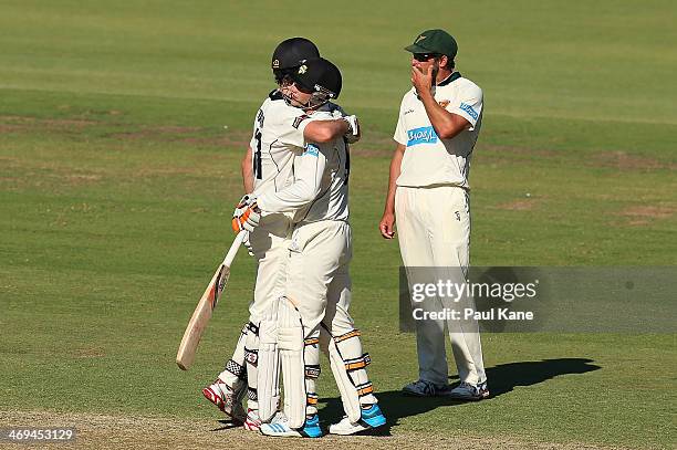 Ashton Turner and Sam Whiteman of the Warriors celebrate defeating the Tigers as Ben Hilfenhaus of the Tigers looks on during day four of the...