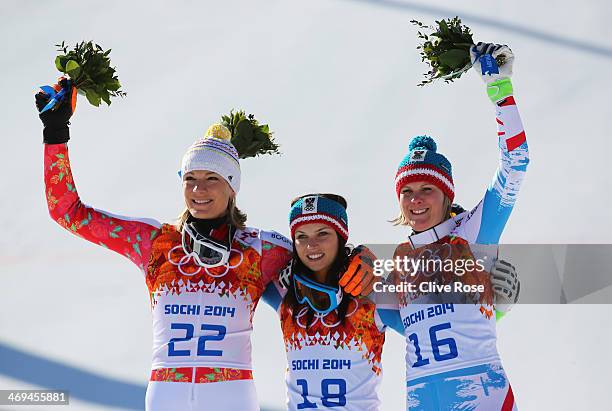 Silver medalist Maria Hoefl-Riesch of Germany, gold medalist Anna Fenninger of Austria and bronze medalist Nicole Hosp of Austria celebrate during...