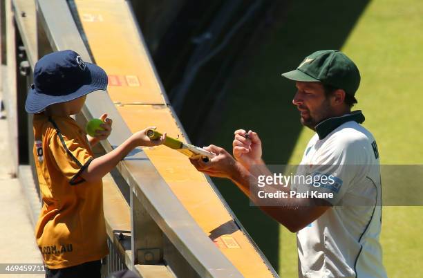 Ben Hilfenhaus of the Tigers signs a bat for young spectator during day four of the Sheffield Shield match between the Western Australia Warriors and...