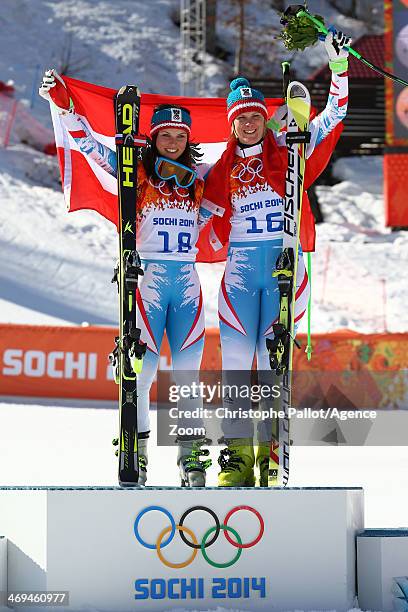 Gold medalist Anna Fenninger of Austria and bronze medalist Nicole Hosp of Austria celebrate on the podium during the flower ceremony for the Alpine...