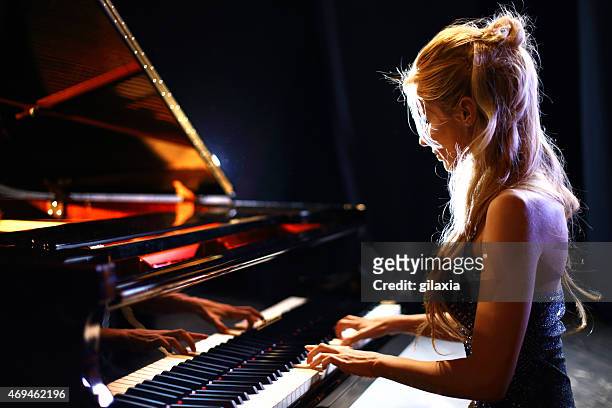 woman playing piano in a concert. - piano stock pictures, royalty-free photos & images