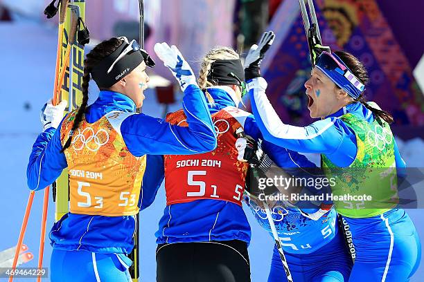 Kerttu Niskanen, Anne Kylloenen, Krista Lahteenmaki and Aino-Kaisa Saarinen of Finland celebrate winning the silver medal in the Women's 4 x 5 km...