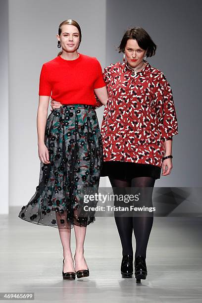 Designer Holly Fulton appears on the runway alongside a model after the Holly Fulton show during London Fashion Week AW14 at Somerset House on...