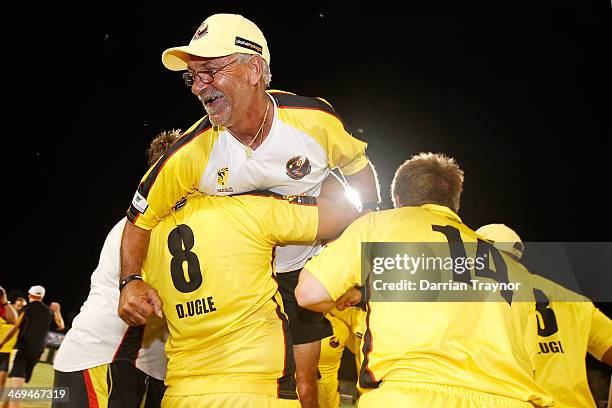 Western Australian team manager Ash Taylor embraces his players after their win in the Imparja Cup Final between Western Australia and New South...