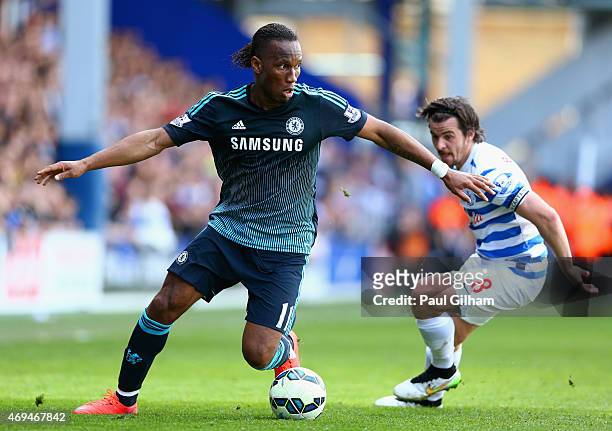 Didier Drogba of Chelsea breaks away from Joey Barton of QPR during the Barclays Premier League match between Queens Park Rangers and Chelsea at...