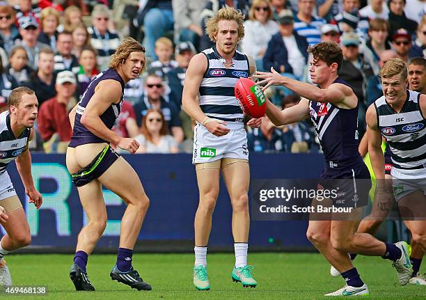 Lachie Neale of the Dockers kicks the ball as Nathan Fyfe of the Dockers loses his shorts during the round two AFL match between the Geelong Cats and...