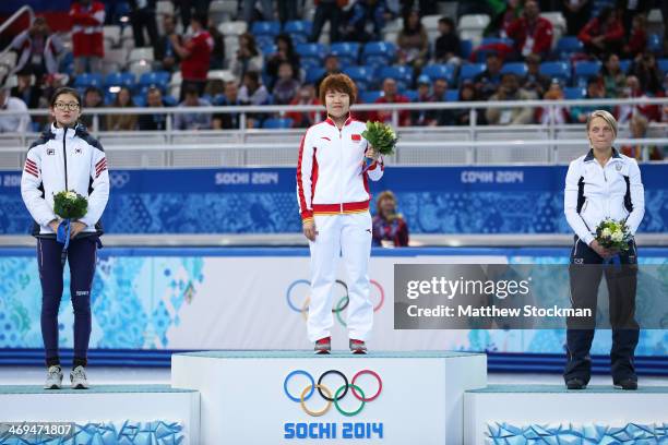 Gold medallist Yang Zhou of China stands on the podium during the flower ceremony with silver medallist Suk Hee Shim of South Korea and bronze...