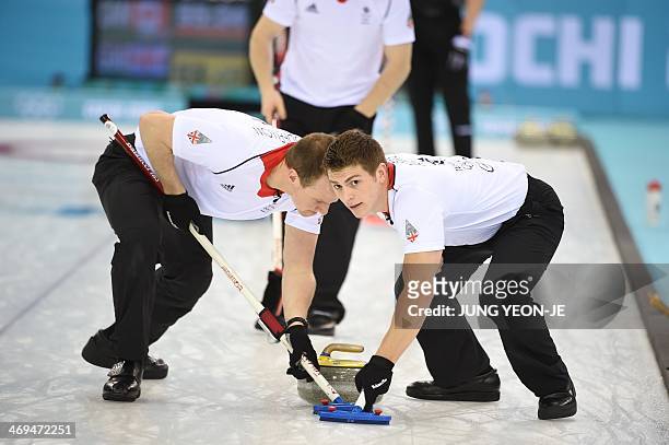 Britain's Scott Andrews and Michael Goodfellow sweep in front of the stone during the Men's Curling Round Robin Session 9 match Canada vs Great...
