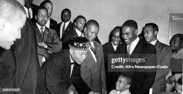 Elijah Muhammad, the leader of Nation of Islam, addressing a young boy surrounded by a group of men, Boston, Massachusetts, 1963.