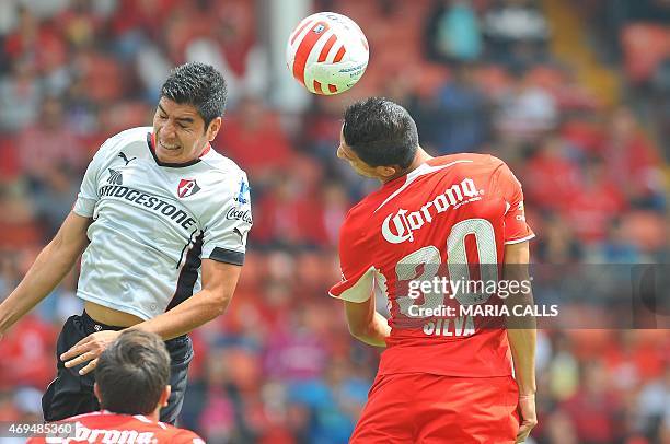 Enrique Perez of Atlas vies for the ball with Jordan Silva of Toluca during their Mexican Clausura tournament football match at the Nemesio Diez...