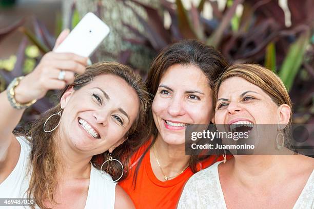 smiling women taking a photo of themselves with phone - selfie three people stock pictures, royalty-free photos & images