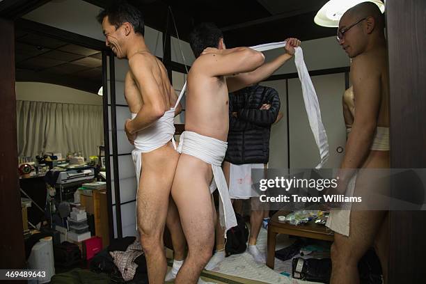 Men help each other dress in loincloths to participate in the Hadaka Matsuri, or Naked Festival at Saidaiji Temple on February 15, 2014 in Okayama,...