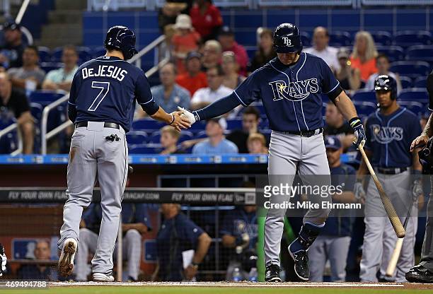 David DeJesus is congratulated by Evan Longoria of the Tampa Bay Rays after scoring during a game against the Miami Marlins at Marlins Park on April...