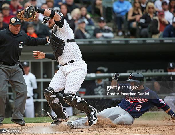 Tyler Flowers of the Chicago White Sox misplays the ball as Brian Dozier of the Minnesota Twins scores a run in the 8th inning at U.S. Cellular Field...