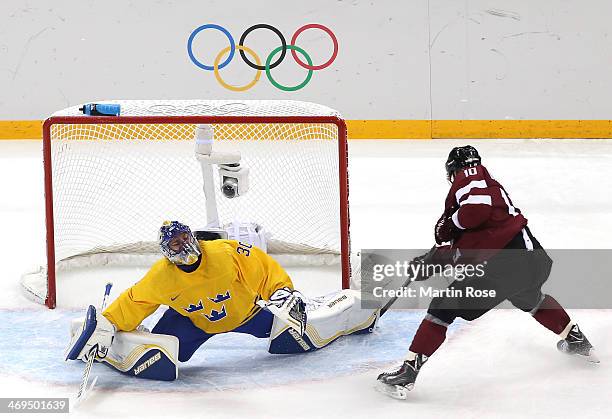 Lauris Darzins of Latvia shoots and scores against Henrik Lundqvist of Sweden in the first period during the Men's Ice Hockey Preliminary Round Group...