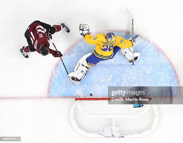 Lauris Darzins of Latvia shoots and scores against Henrik Lundqvist of Sweden in the first period during the Men's Ice Hockey Preliminary Round Group...