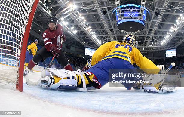 Lauris Darzins of Latvia shoots and scores against Henrik Lundqvist of Sweden in the first period during the Men's Ice Hockey Preliminary Round Group...