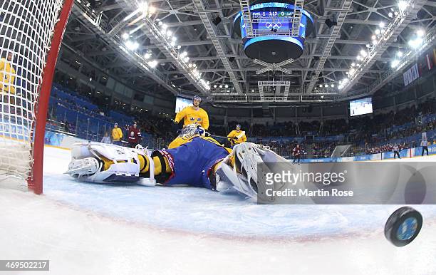 Lauris Darzins of Latvia shoots and scores against Henrik Lundqvist of Sweden in the first period during the Men's Ice Hockey Preliminary Round Group...