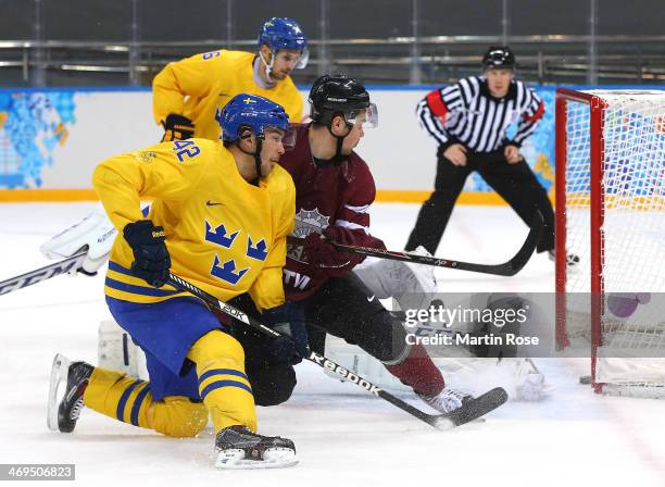 Jimmie Ericsson of Sweden scores against Kristers Gudlevskis of Latvia in the second period during the Men's Ice Hockey Preliminary Round Group C...