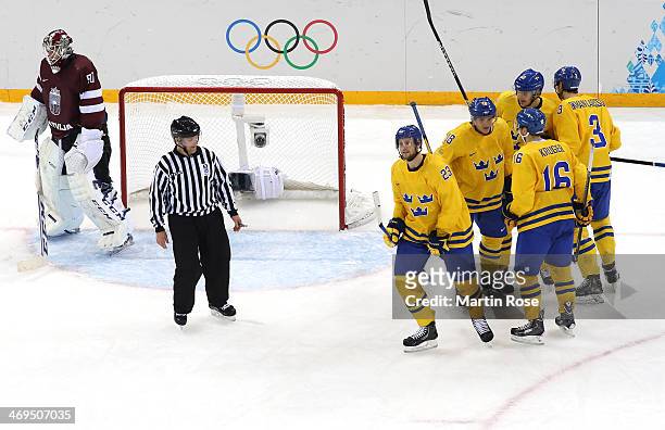 Jimmie Ericsson of Sweden celebrates with teammates after scoring against Kristers Gudlevskis of Latvia in the second period during the Men's Ice...