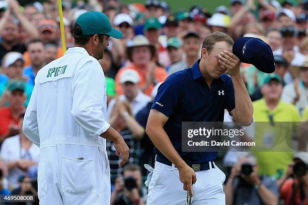 Jordan Spieth of the United States celebrates with his caddie Michael Greller on the 18th green after his four-stroke victory at the 2015 Masters...