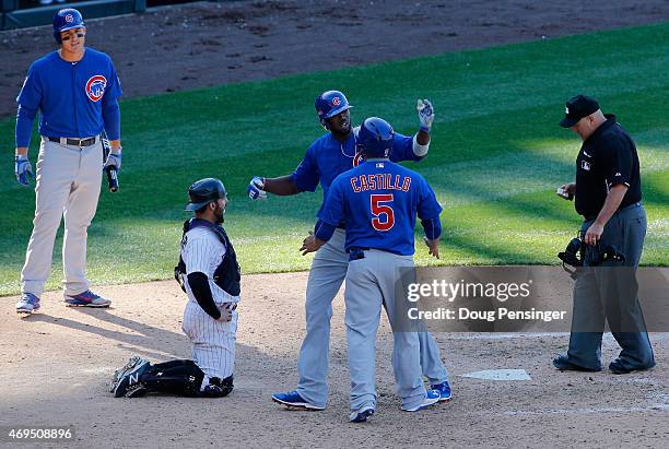 Dexter Fowler of the Chicago Cubs celebrates his game winning two run home run with Welington Castillo of the Chicago Cubs as catcher Michael McKenry...