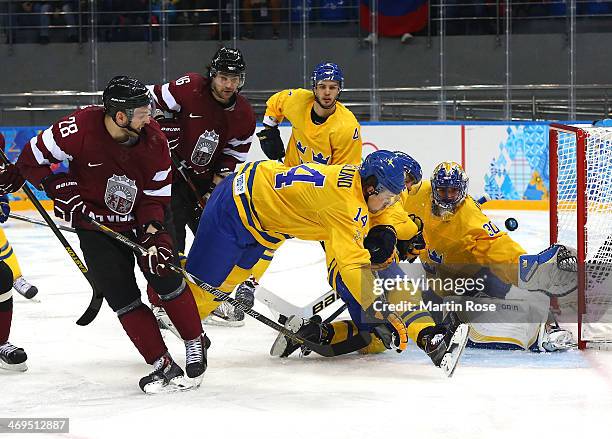 Zemgus Girgensons of Latvia shoots and scores against Henrik Lundqvist of Sweden in the third period during the Men's Ice Hockey Preliminary Round...