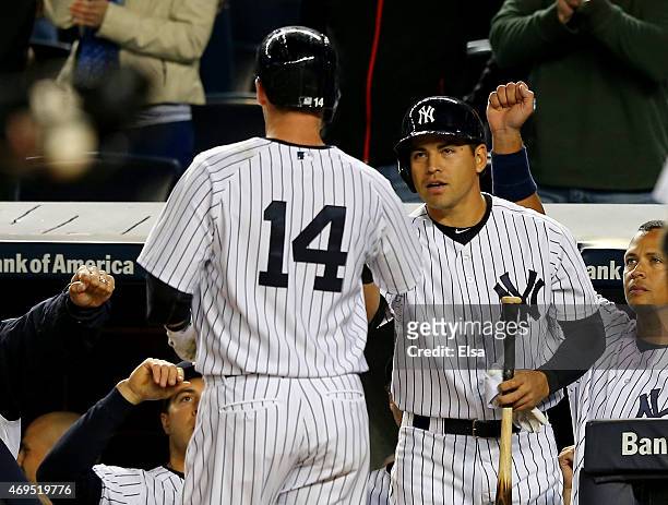 Stephen Drew of the New York Yankees is congratulated by teammate Jacoby Ellsbury after Drew hit a solo home run in the first inning against the...