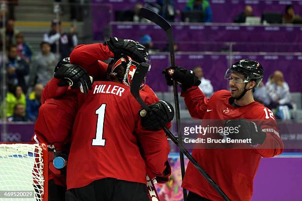 Jonas Hiller of Switzerland celebratse with his teammate Luca Cunti after defeating the Czech Republic 1 to 0 in the Men's Ice Hockey Preliminary...