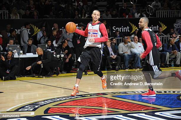 Stephen Curry of the Western Conference All-Stars handles the ball against Tony Parker during NBA All-Star Practice at Sprint Arena as part of 2014...