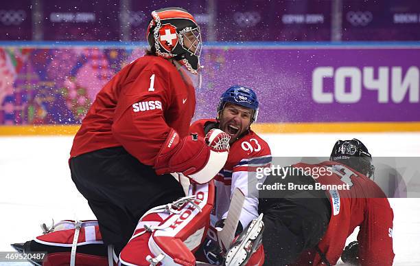 Petr Nedved of the Czech Republic and Roman Wick of Switzerland come crashing into Jonas Hiller after a play at the net during the Men's Ice Hockey...