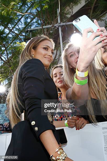 Actress/singer Jennifer Lopez poses for a selfie photo with fans at The 2015 MTV Movie Awards at Nokia Theatre L.A. Live on April 12, 2015 in Los...