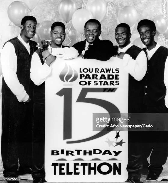 Four man singing group, Boyz II Men, specialists in R&B soul and acapella music posing with a large fund raising placard during a telethon, Lou...