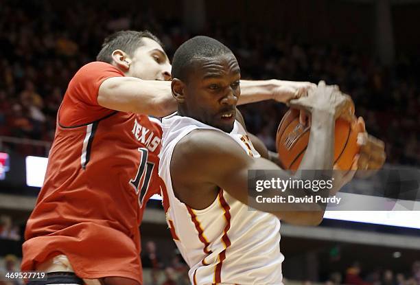 Dejan Kravic of the Texas Tech Red Raiders reaches over the back of Dustin Hogue of the Iowa State Cyclones as he pulls in a rebound in the first...