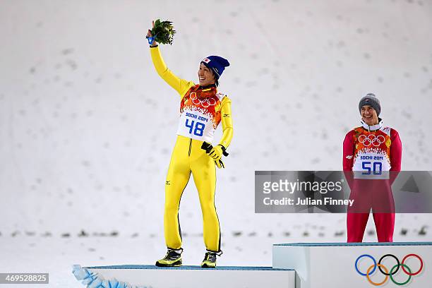 Silver medalist Noriaki Kasai of Japan celebrates on the podium next to Kamil Stoch of Poland during the flower ceremony after the Men's Large Hill...