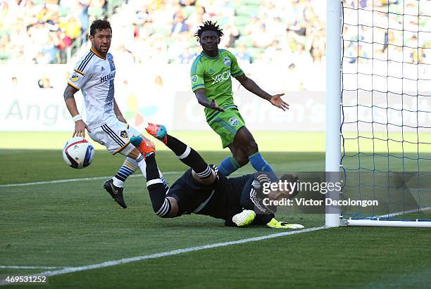 Goalkeeper Jaime Penedo of Los Angeles Galaxy makes a save as teammate Dan Gargan marks Obafemi Martins of Seattle Sounders FC in the second half of...