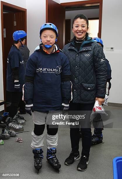 Laureus World Sports Academy member Yang Yang of China poses with a young boy as she visits a Laureus Sport For Good Project prior to the Laureus...