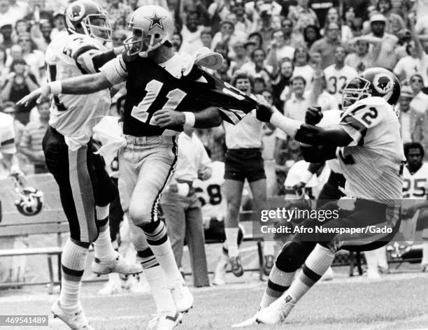 Photograph of a football game of the Dallas Cowboys vs Washington Redskins, with Skin's defensive end Dexter Manley, no 72, holding on to the shirt...